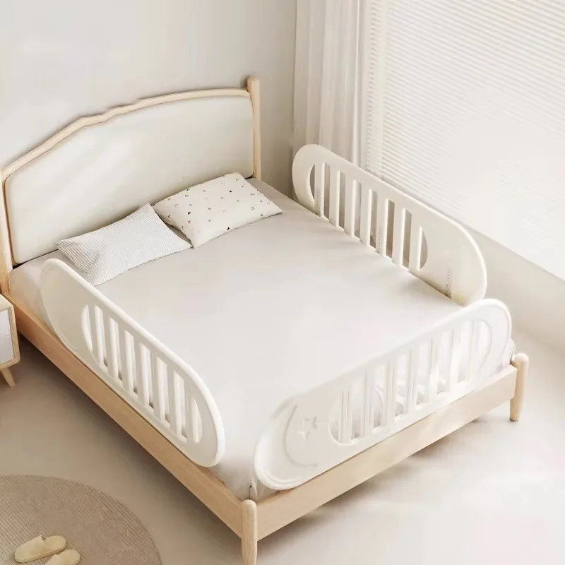 Dos barandas blancas con barrotes y una luna en relieve, puestas a cada lado de una cama