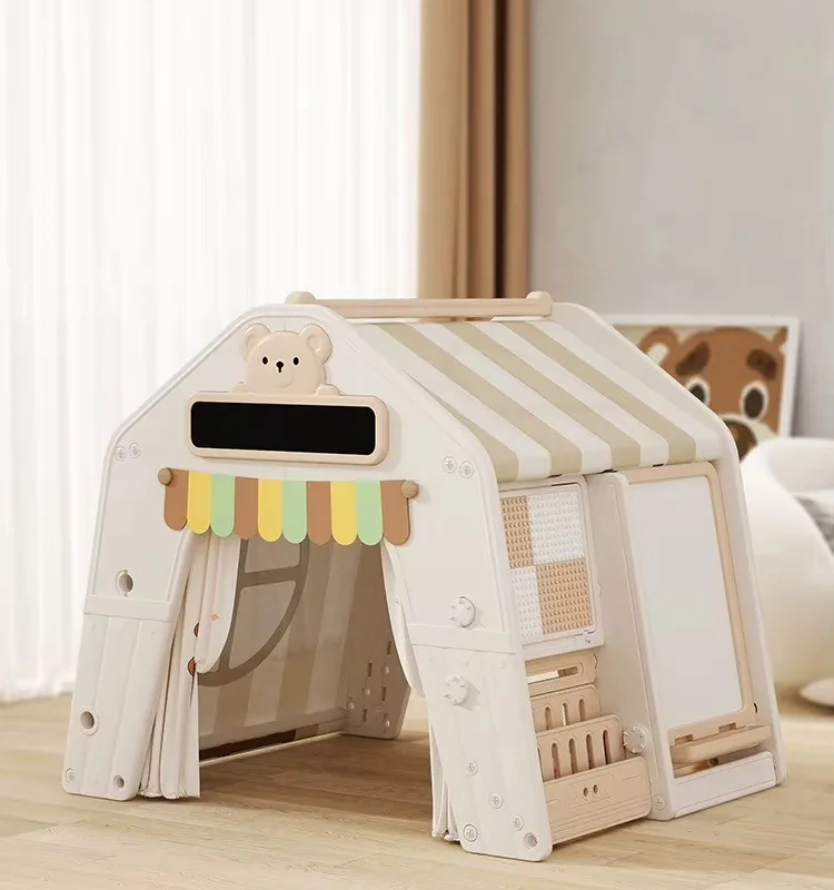 Casita de juego blanca con techo de rayas beige, toldito de colores y pizarra blanca al costado
