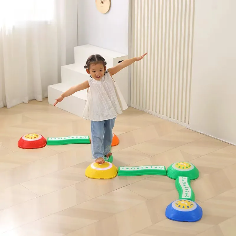 Niña caminando sobre el circuito de piedras de colores unidas por puentes verdes