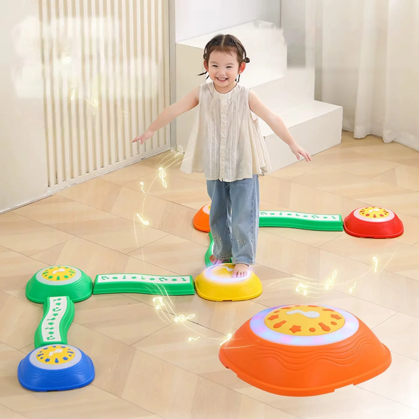 Niña pisando una piedra iluminada del circuito, con puentes verdes y piedras de colores en el piso