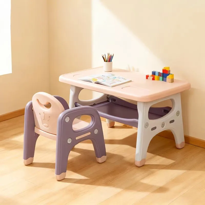 Mesa y silla en rosado con morado y gris, con un cuaderno, lápices y bloques sobre la mesa