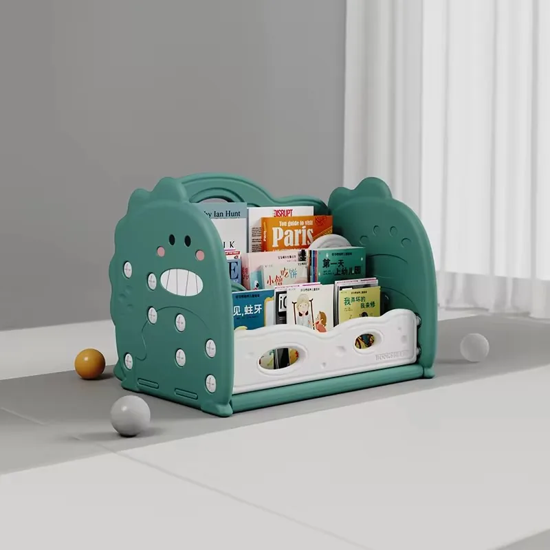 Librerito de piso verde con laterales en forma de dinosaurio sonriente y cuentos de frente