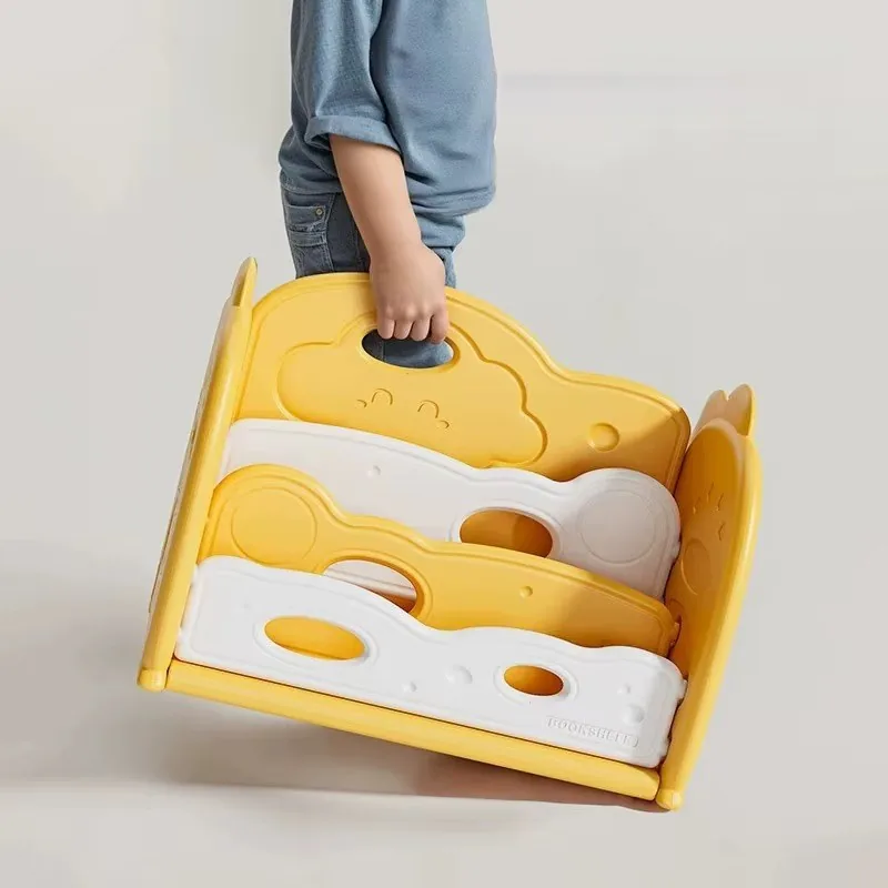 Niño cargando el librerito amarillo de la agarradera en forma de nube
