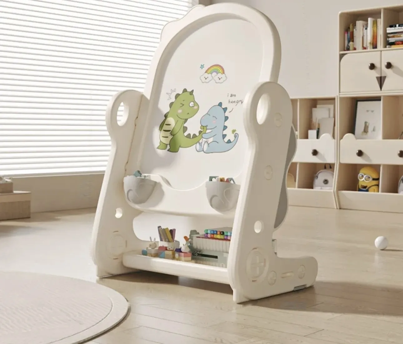 Pizarra de pie blanca con crestas de dinosaurio, dibujos de dinosaurios y repisa para marcadores, en un cuarto de juegos