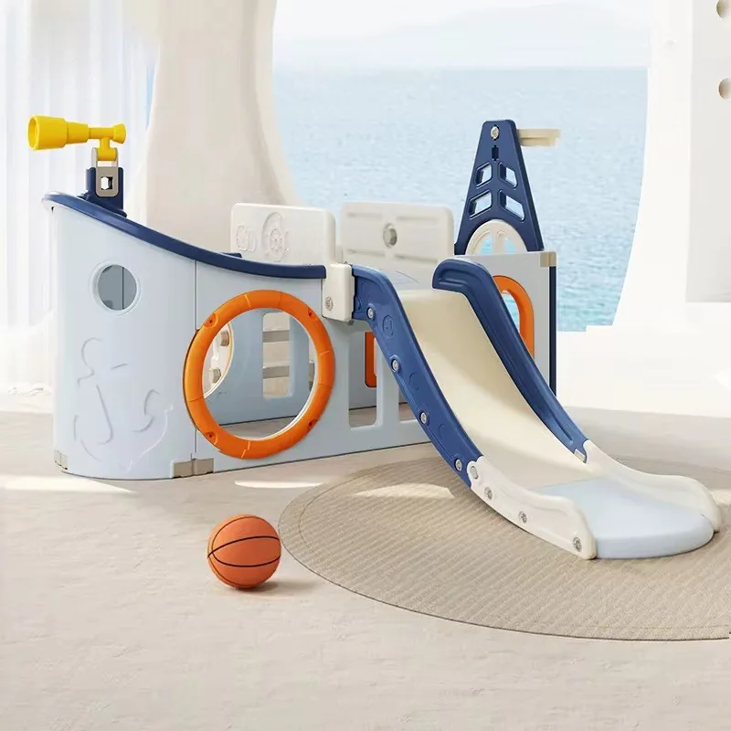 Play de barco pirata celeste con catalejo amarillo, aro de básquet y tobogán, junto a una pelota