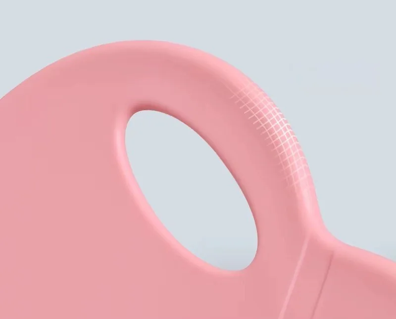 Acercamiento al asa calada en el borde del asiento rosado de la silla con forma de dinosaurio