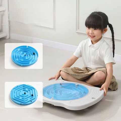 Niña sentada junto a la tabla con laberinto celeste y dos recuadros con un laberinto circular y otro hexagonal